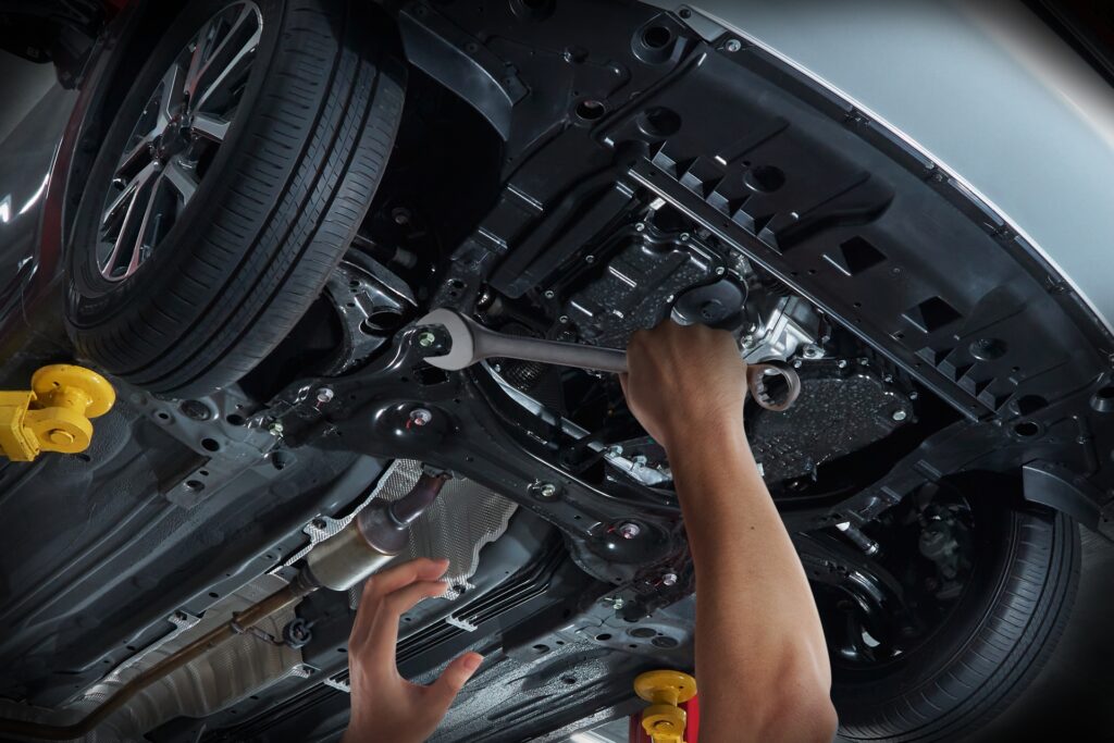 Mechanic,Repairing,Car,Undercarriage,With,Wrench,In,Auto,Service,Workshop